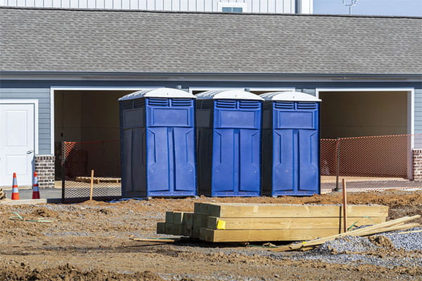 portable toilets staged behind a privacy fence for a private wedding reception