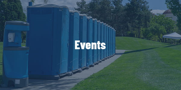 porta potty units placed behind picnic tables at corporate company picnic under oak trees in Watertown SD